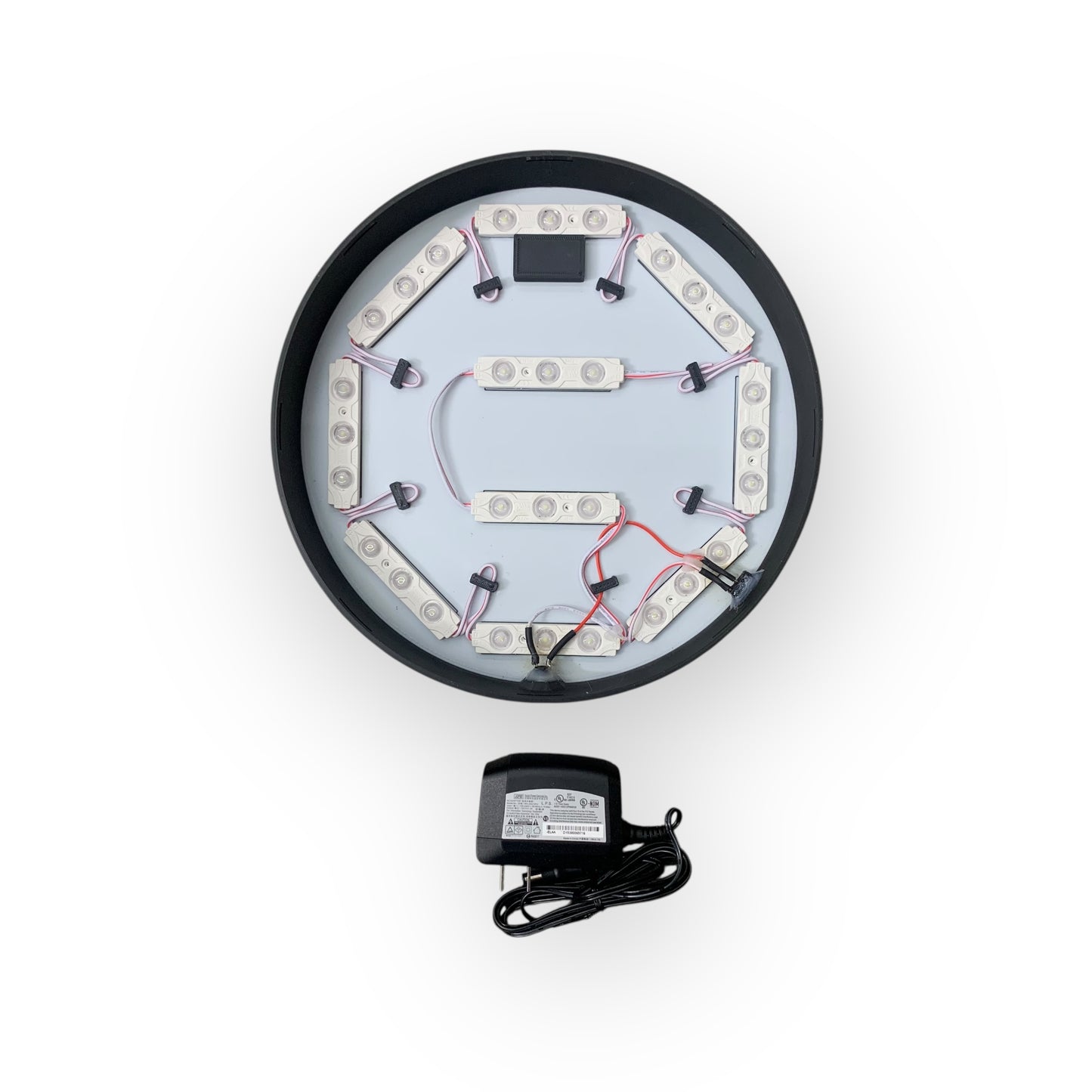 Inside of LED indoor BRP sign showing 12V led modules with a power adapter on a white background