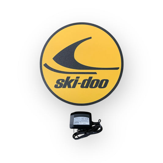 Ski-Doo led indoor sign on a yellow background with a power adapter below.